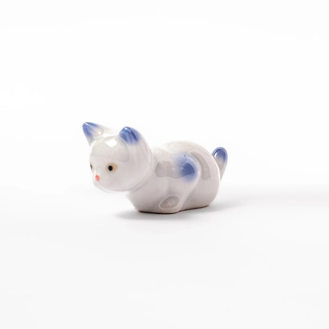 White porcelain kitten-shaped chopstick rest with blue-tipped ears, tail, and body accents, featuring a small red nose.