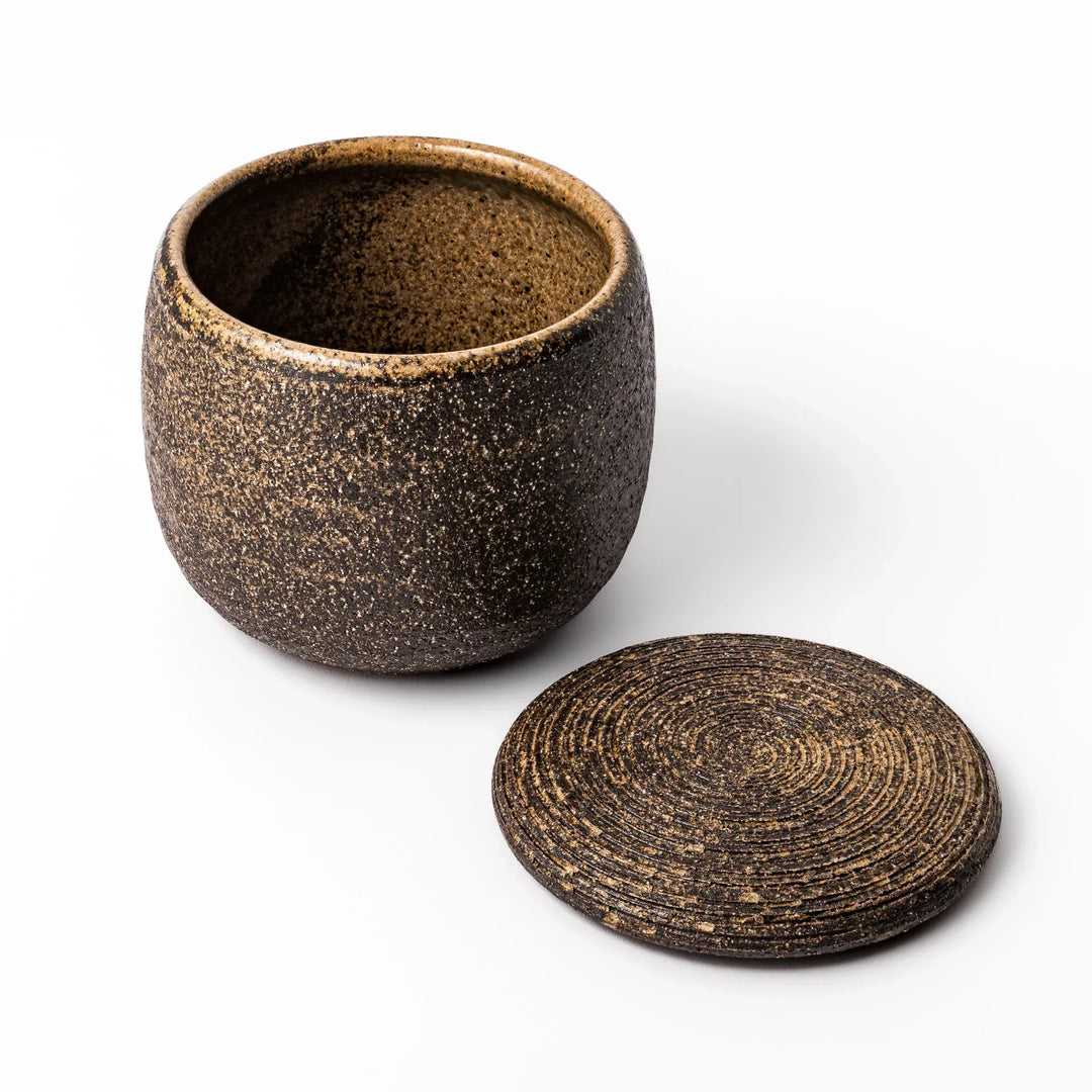 Dark brown ceramic rice storage bowl with lid and rustic texture for storing and serving cooked rice.