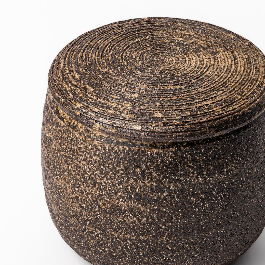 Dark brown ceramic rice storage bowl with lid and rustic texture for storing and serving cooked rice.