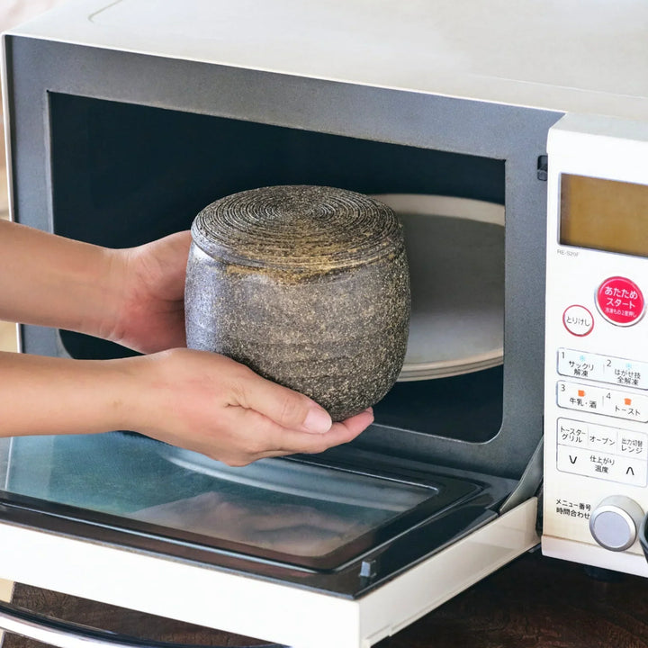 Dark brown ceramic rice storage bowl with lid and rustic texture for storing and serving cooked rice.