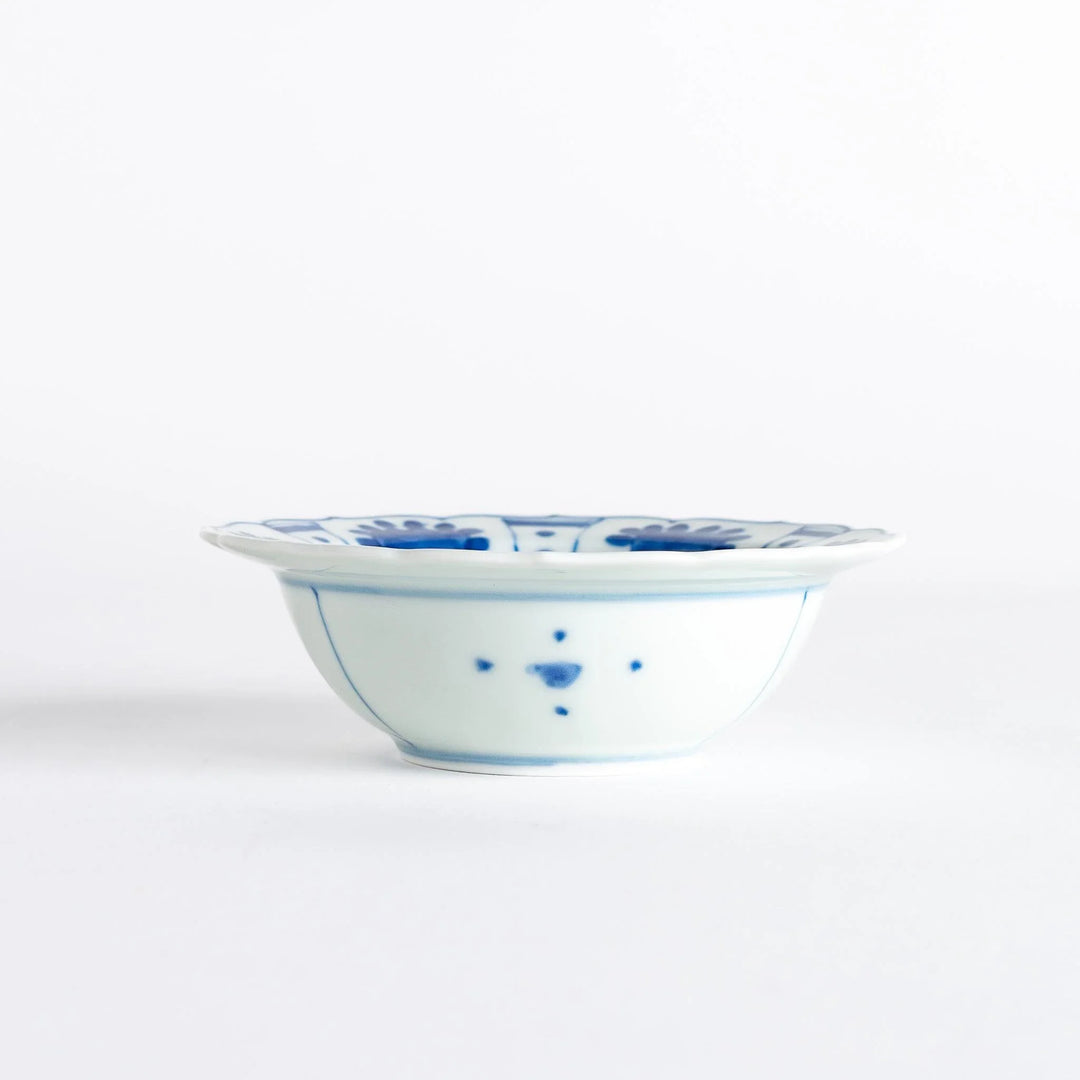 A dessert bowl with a scalloped edge, decorated in blue with pastoral scenes of deer and landscape motifs.