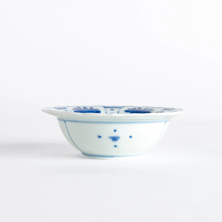 A dessert bowl with a scalloped edge, decorated in blue with pastoral scenes of deer and landscape motifs.