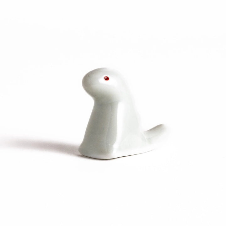 White ceramic dinosaur chopstick rest bringing playful charm to table settings while keeping chopsticks clean.