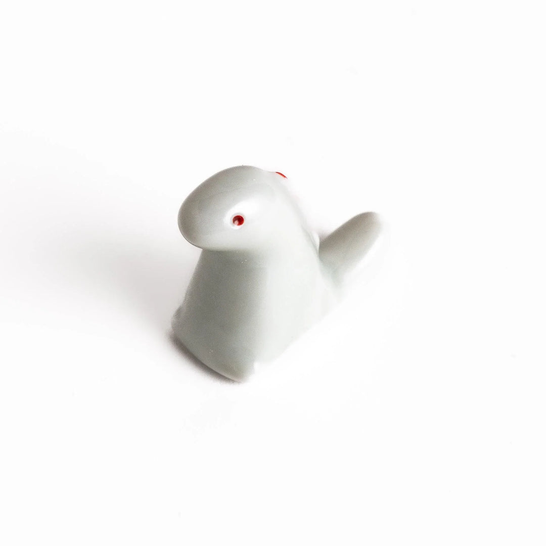 White ceramic dinosaur chopstick rest bringing playful charm to table settings while keeping chopsticks clean.