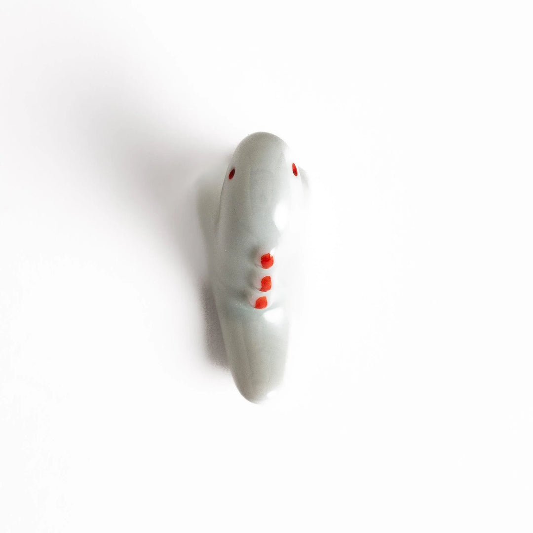 White ceramic dinosaur chopstick rest bringing playful charm to table settings while keeping chopsticks clean.