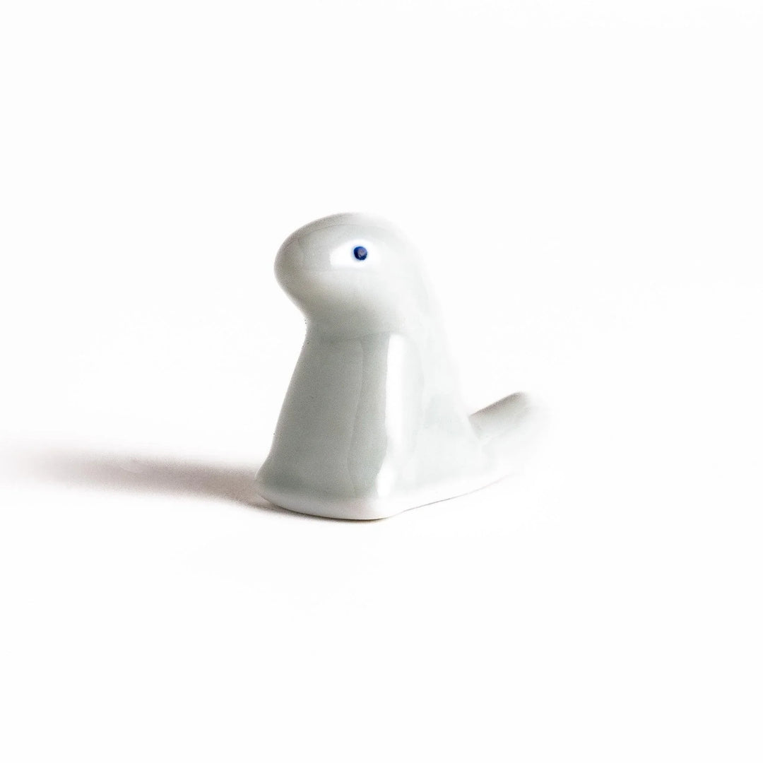 White ceramic dinosaur chopstick rest bringing playful charm to table settings while keeping chopsticks clean.