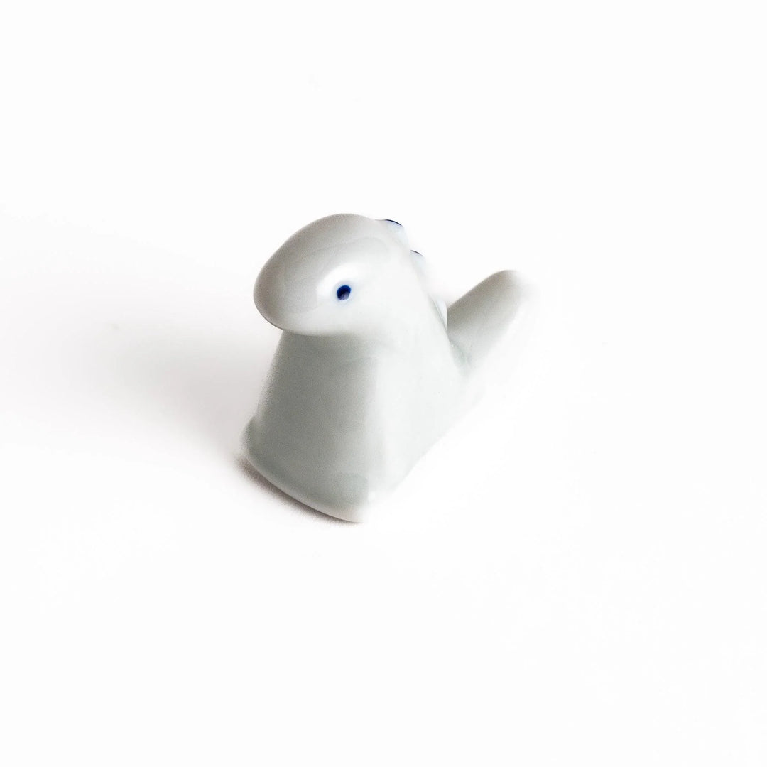 White ceramic dinosaur chopstick rest bringing playful charm to table settings while keeping chopsticks clean.