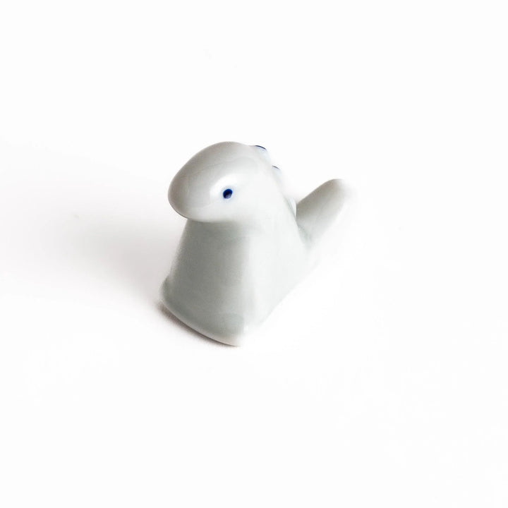 White ceramic dinosaur chopstick rest bringing playful charm to table settings while keeping chopsticks clean.