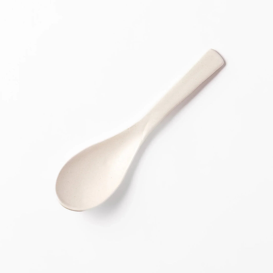 White ceramic scoop spoon with angled handle and deep, curved bowl for smooth serving of soup, stew, or curry.