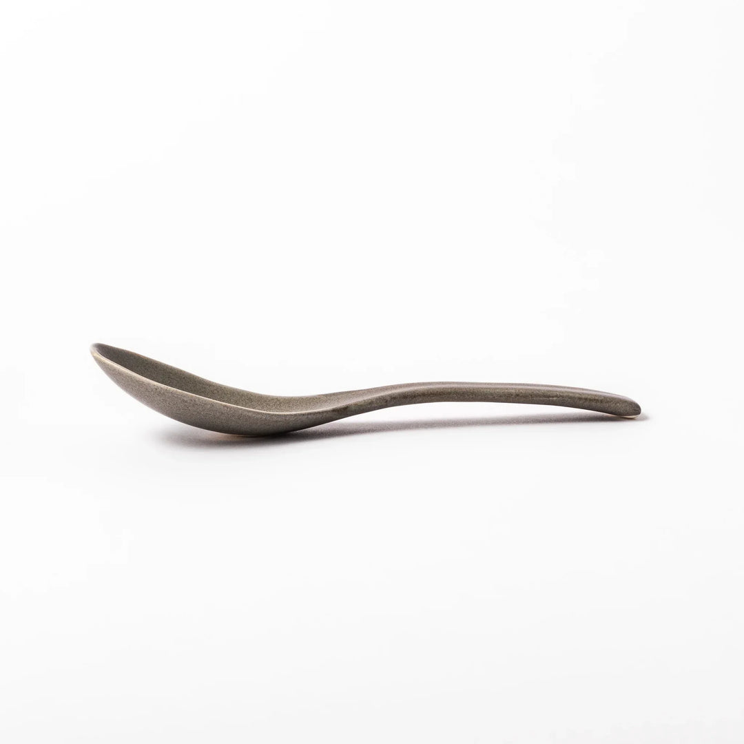 Gray Japanese ceramic spoon with wide curved bowl and angled handle for serving soups stews and curry.