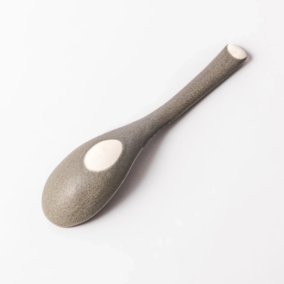Gray Japanese ceramic spoon with wide curved bowl and angled handle for serving soups stews and curry.