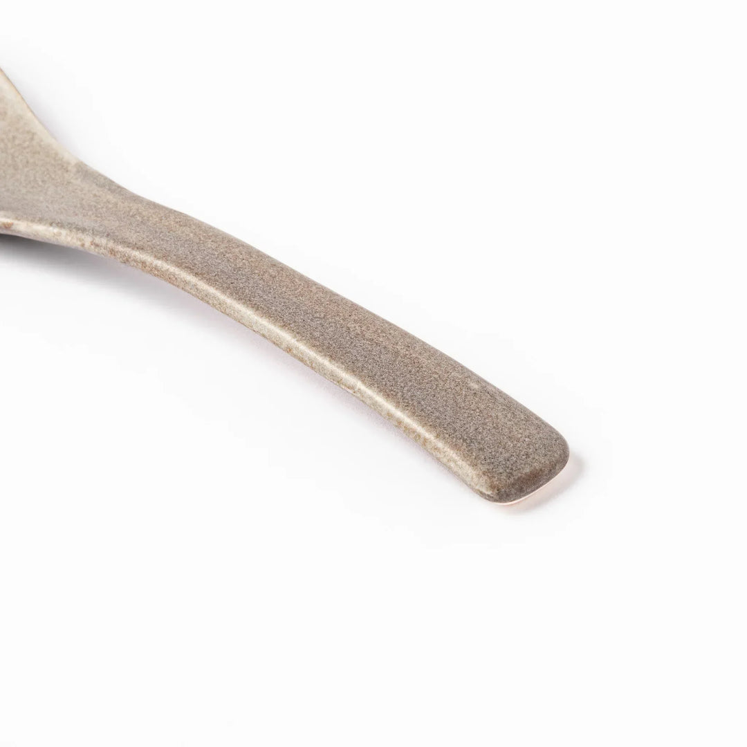 Gray Japanese ceramic spoon with wide curved bowl and angled handle for serving soups stews and curry.