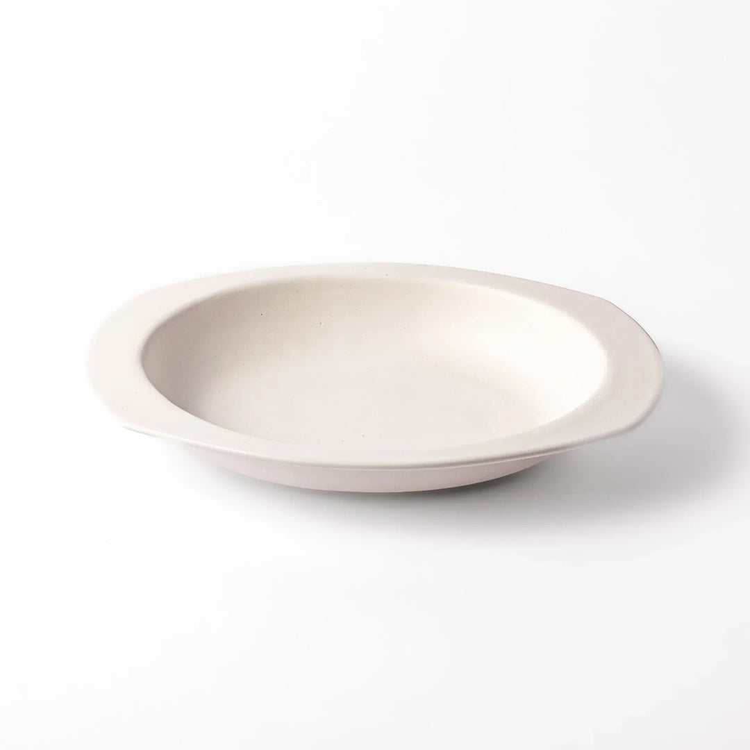 White Japanese oval ceramic curry plate with wide rim and curved sides for serving curry rice or pasta.