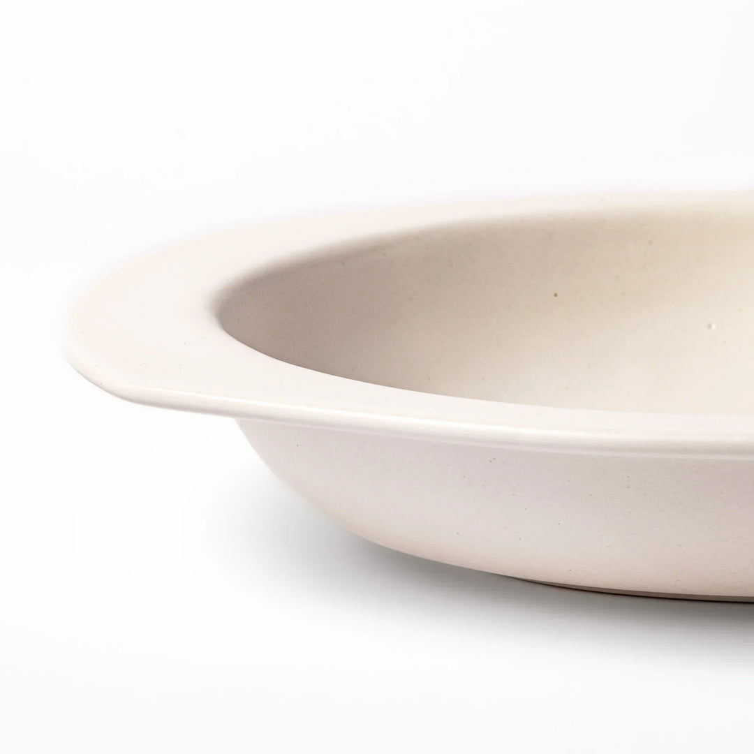 White Japanese oval ceramic curry plate with wide rim and curved sides for serving curry rice or pasta.