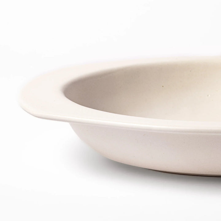 White Japanese oval ceramic curry plate with wide rim and curved sides for serving curry rice or pasta.