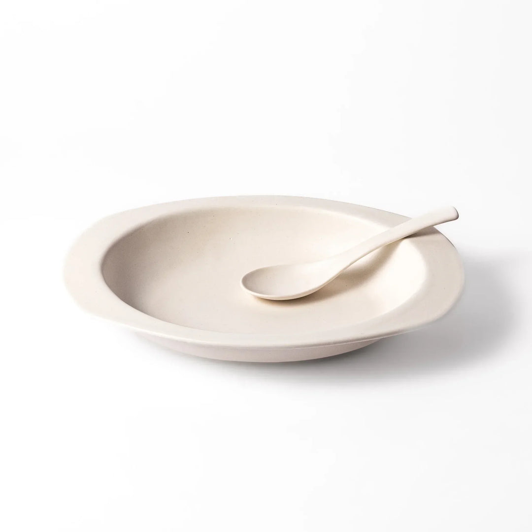 White Japanese oval ceramic curry plate with wide rim and curved sides for serving curry rice or pasta.