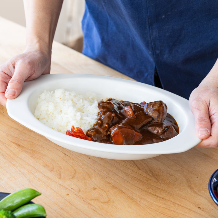 Nami from Just One Cookbook holding oval ceramic curry plate with Japanese curry rice