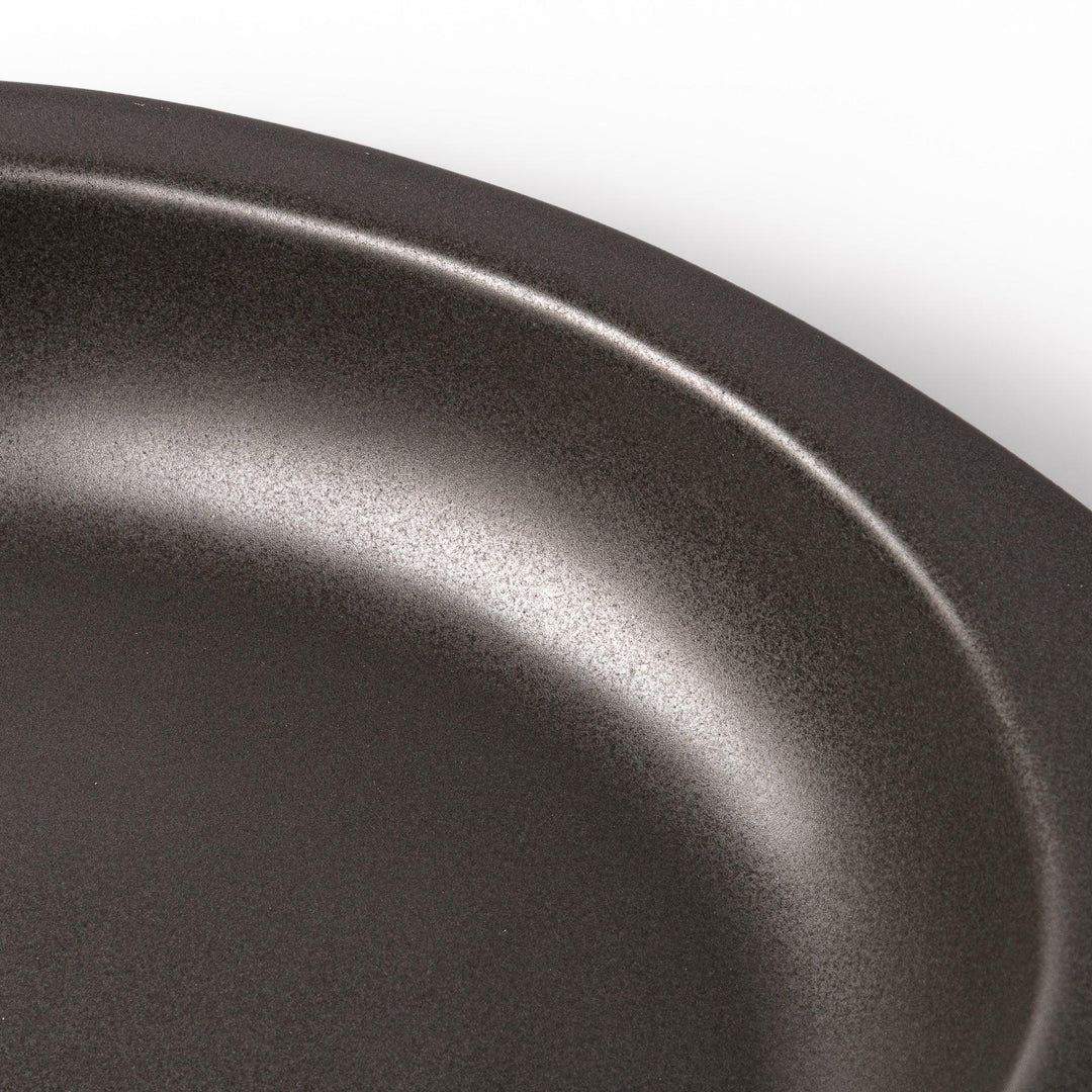 Black Japanese oval ceramic curry plate with wide rim and curved edges for serving curry rice or pasta.