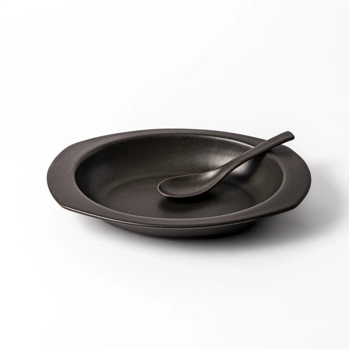 Black Japanese oval ceramic curry plate with wide rim and curved edges for serving curry rice or pasta.
