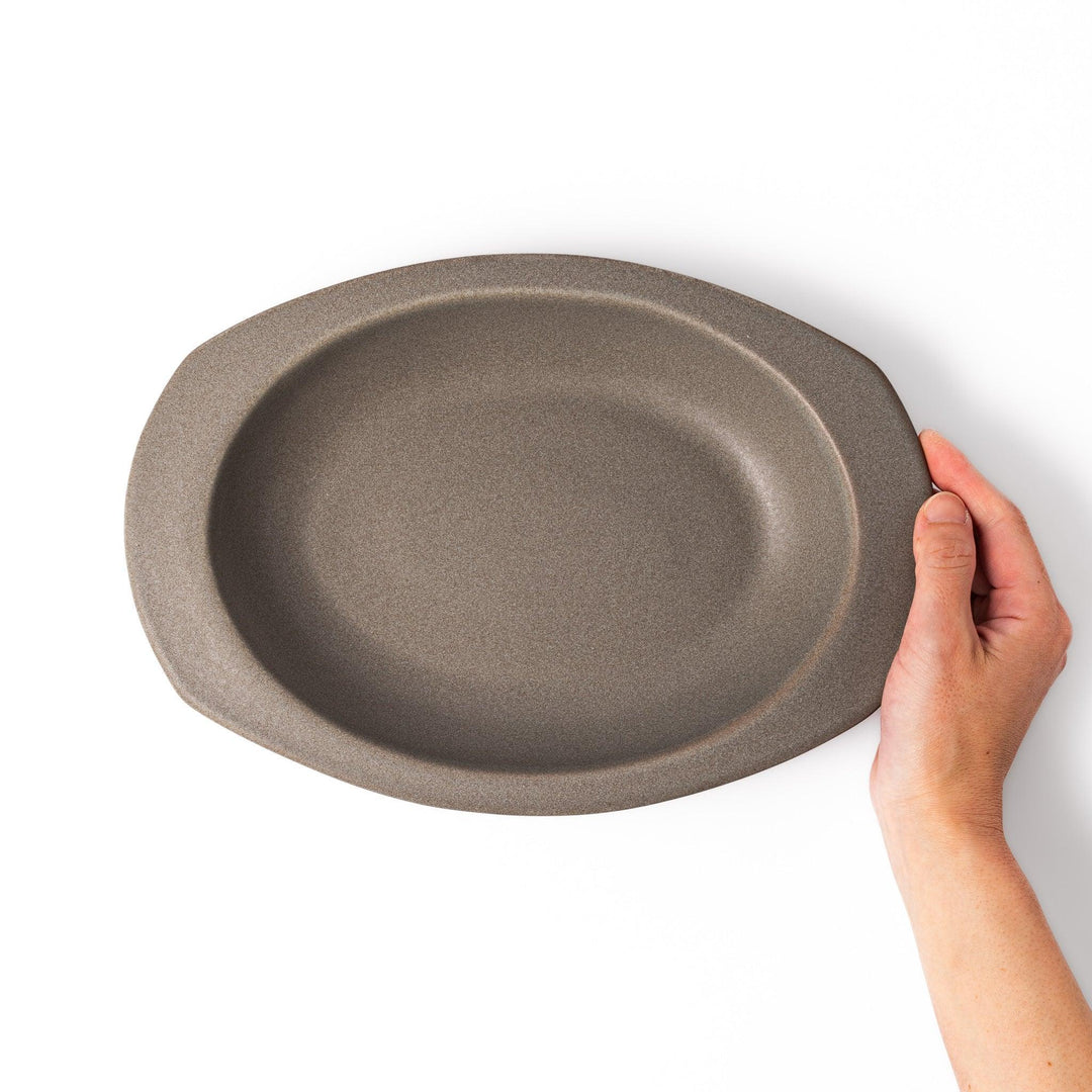 Gray Japanese oval ceramic curry plate with wide rim and raised sides for serving rice curry or stew.