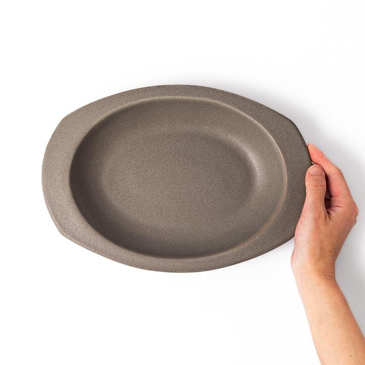 Gray Japanese oval ceramic curry plate with wide rim and raised sides for serving rice curry or stew.