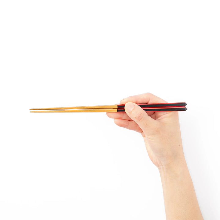Fine tip Japanese bamboo chopsticks featuring a black handle with bold red side stripes and a natural bamboo finish