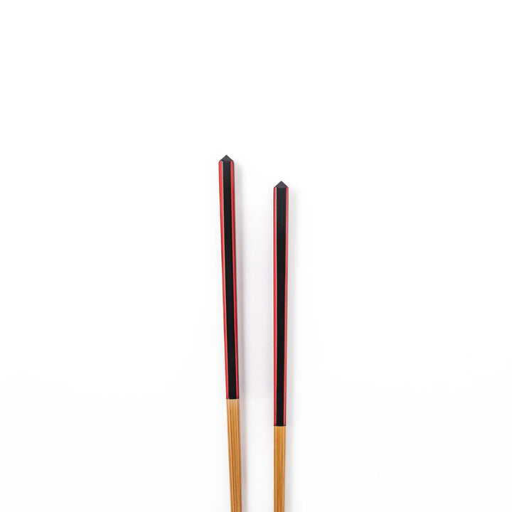 Fine tip Japanese bamboo chopsticks featuring a black handle with bold red side stripes and a natural bamboo finish