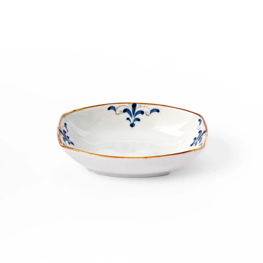 White boat-shaped bowl with blue floral patterns on the inner rim and a rustic brown edge, perfect for cereal or side dishes.
