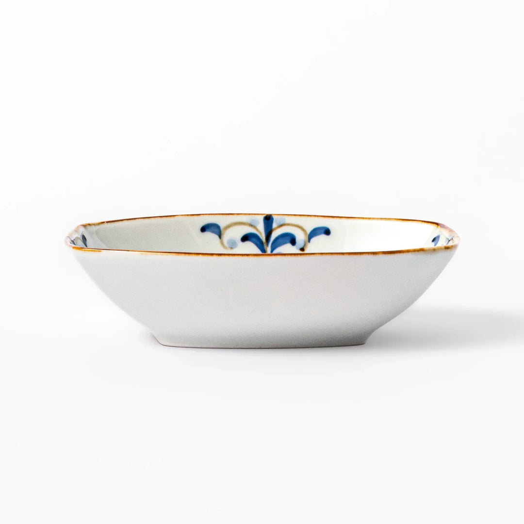 White boat-shaped bowl with blue floral patterns on the inner rim and a rustic brown edge, perfect for cereal or side dishes.