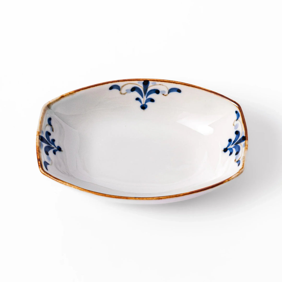 White boat-shaped bowl with blue floral patterns on the inner rim and a rustic brown edge, perfect for cereal or side dishes.
