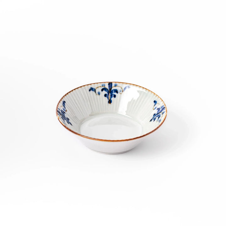 White dessert bowl with vertical ridges, blue floral accents, and brown rim, ideal for serving sweets or fruits.