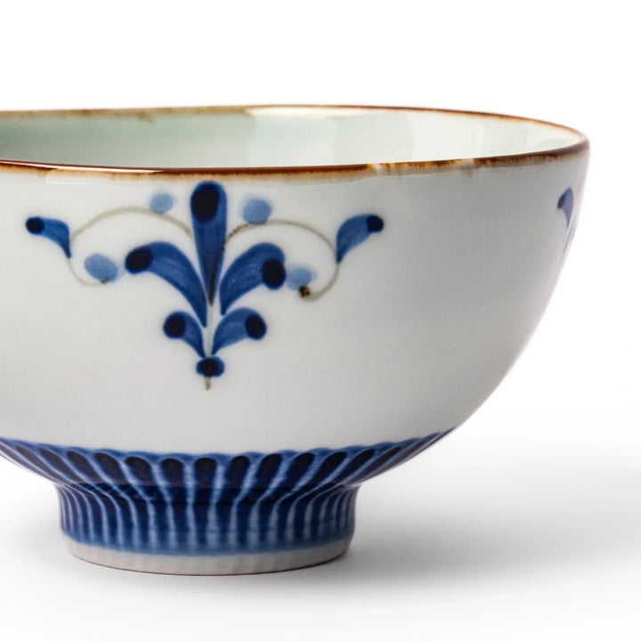 Arita porcelain rice bowl with blue floral leaf motif and gold rim, perfect for serving rice or soup.