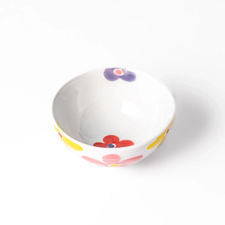 White ceramic kids rice bowl with pink, yellow, red, and purple flower motifs, round footed base