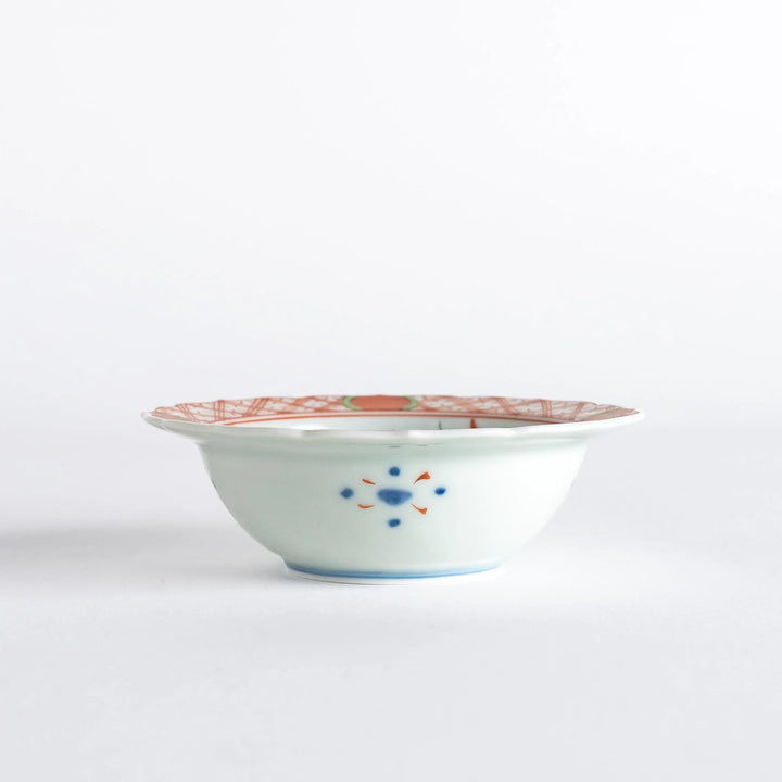 Japanese porcelain dessert bowl with red and green rim designs and blue fortune kanji character center.