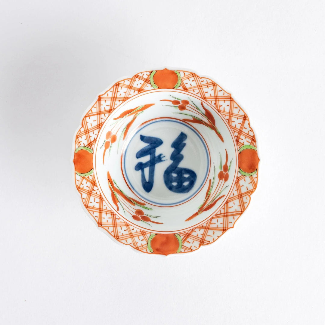 Japanese porcelain dessert bowl with red and green rim designs and blue fortune kanji character center.