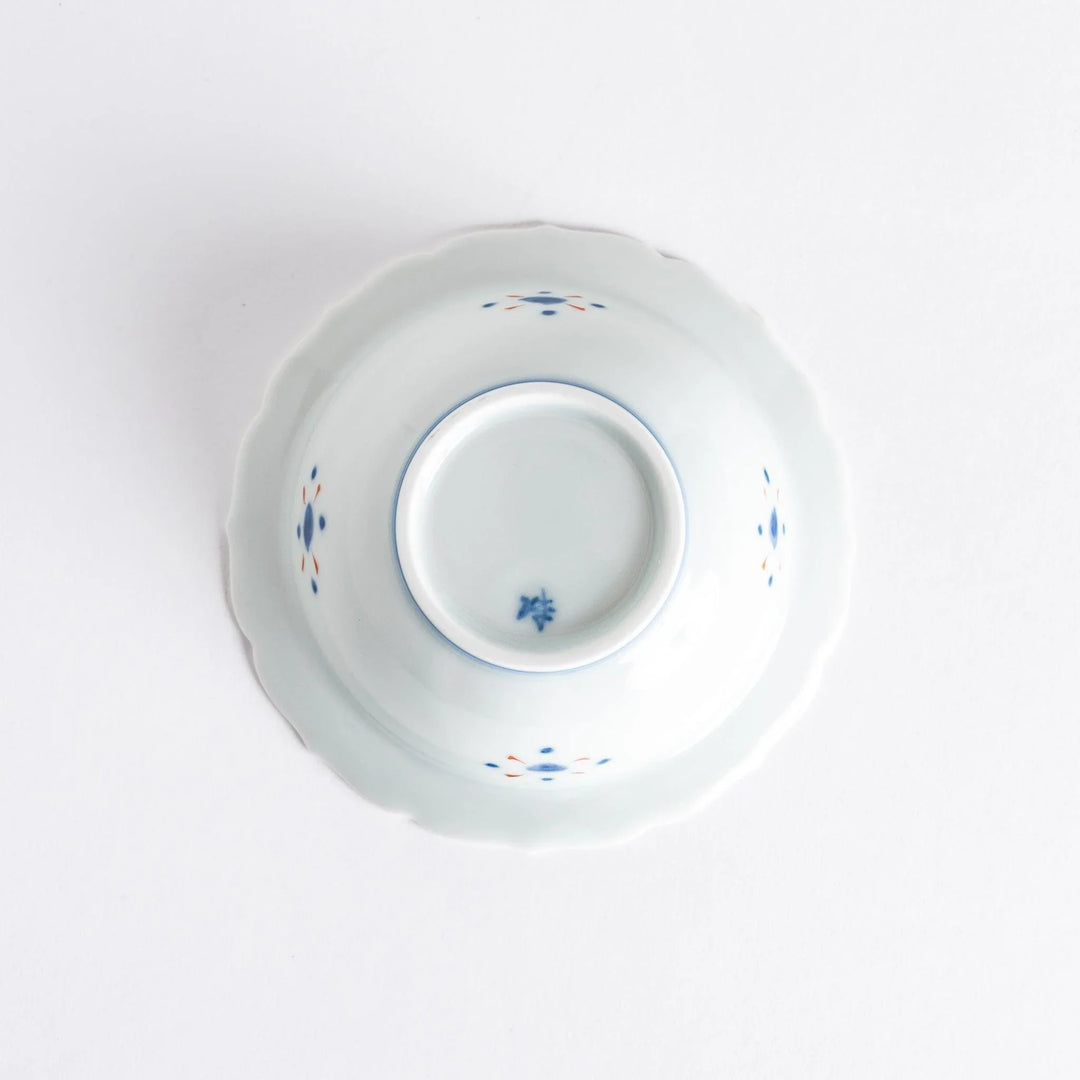 Japanese porcelain dessert bowl with red and green rim designs and blue fortune kanji character center.