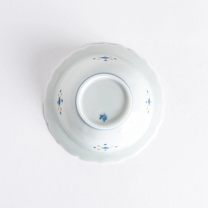 Japanese porcelain dessert bowl with red and green rim designs and blue fortune kanji character center.