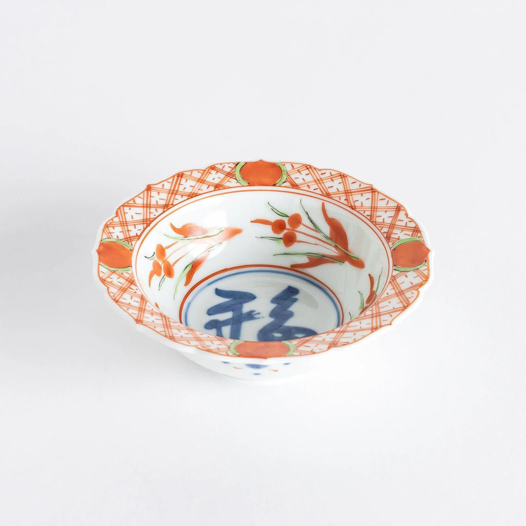 Japanese porcelain dessert bowl with red and green rim designs and blue fortune kanji character center.