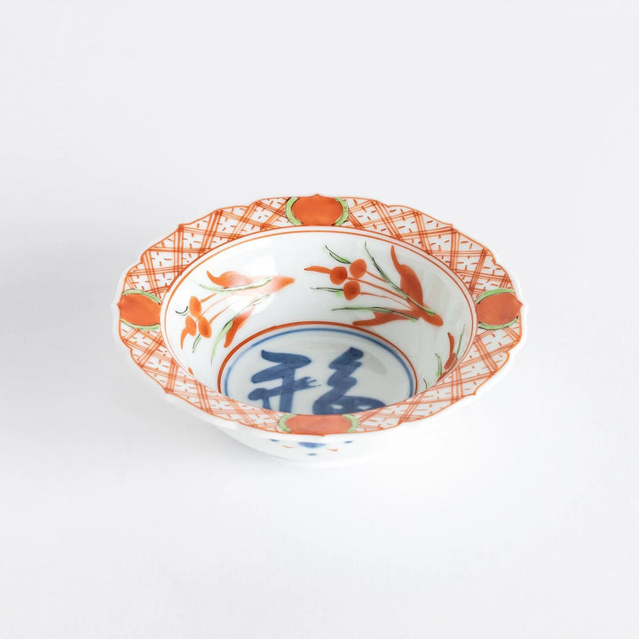 Japanese porcelain dessert bowl with red and green rim designs and blue fortune kanji character center.