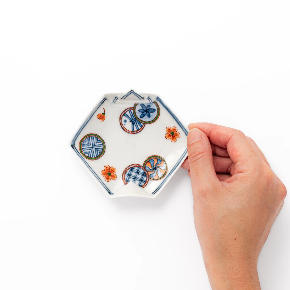 Japanese porcelain origami shaped sauce dish with geometric and floral motifs for soy sauce or condiments.