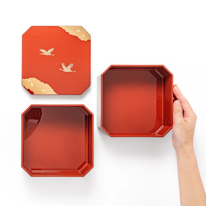 Gold River and Crane Japanese hexagonal jubako box with gold motif on red lacquer for festive food display.