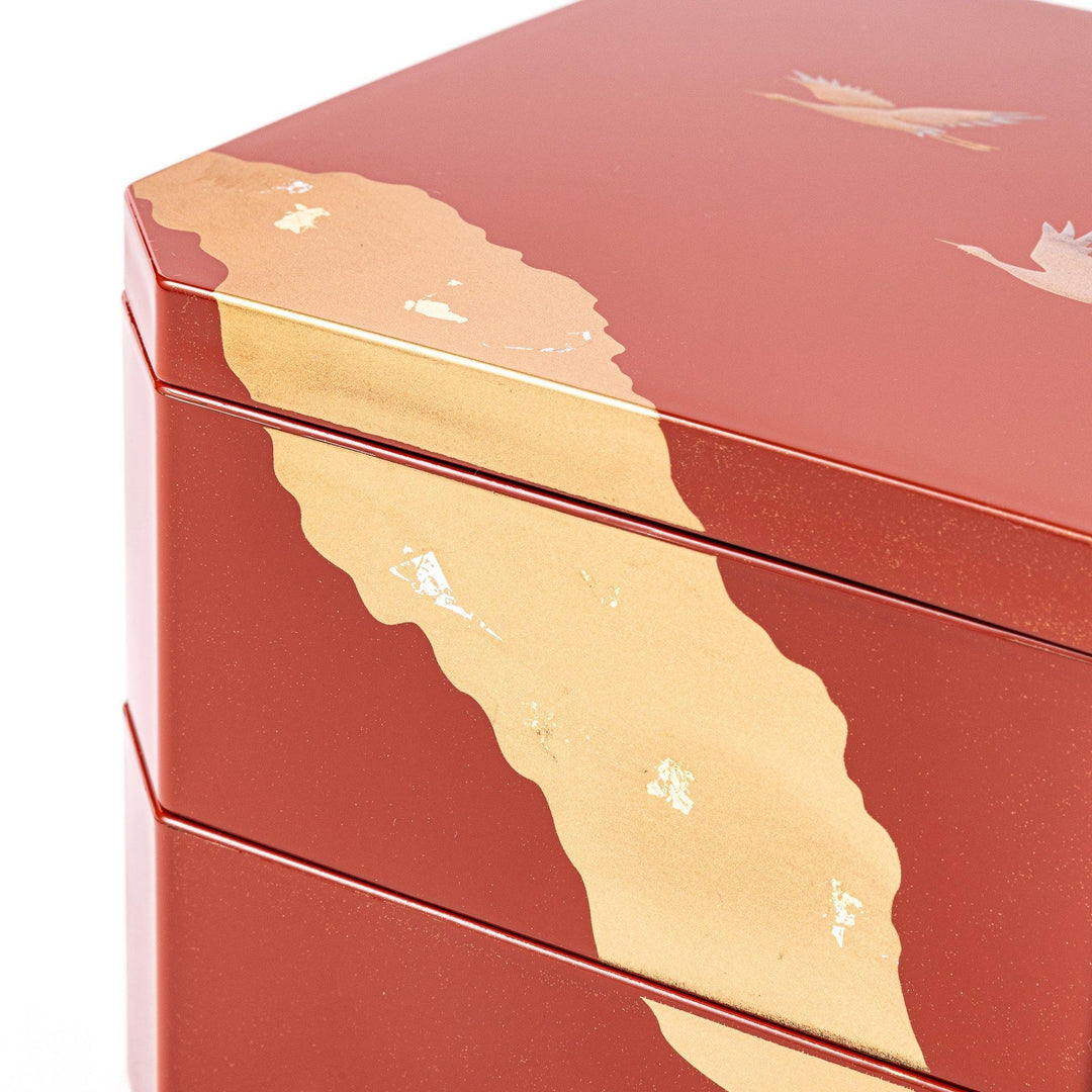Gold River and Crane Japanese hexagonal jubako box with gold motif on red lacquer for festive food display.