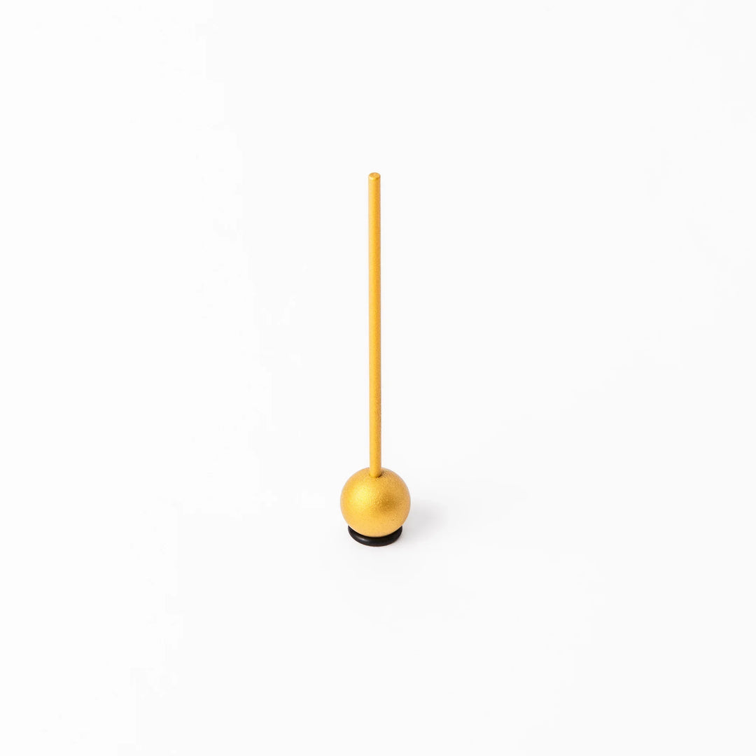 Golden Japanese brass meditation bowl striker with sleek handle and round base for prayer or rituals.