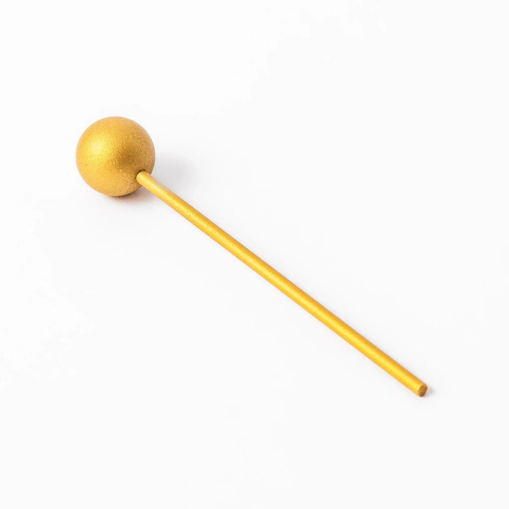 Golden Japanese brass meditation bowl striker with sleek handle and round base for prayer or rituals.