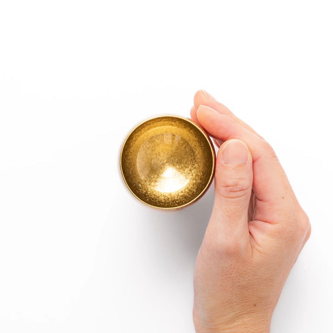 Golden Japanese brass sake cup with rounded base and hammered texture for refined traditional drinking.