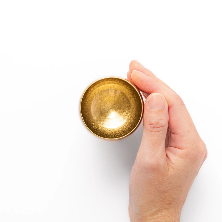 Golden Japanese brass sake cup with rounded base and hammered texture for refined traditional drinking.