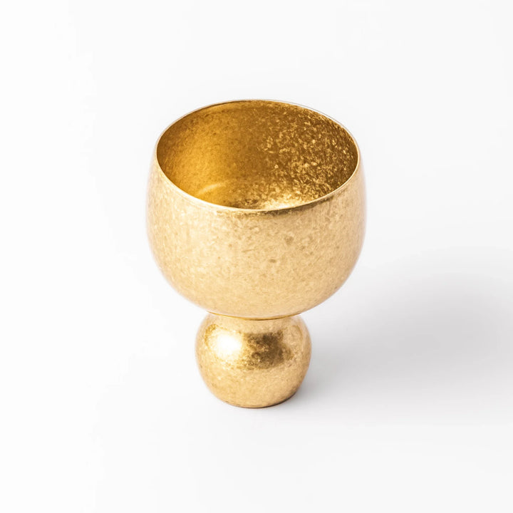 Golden Japanese brass sake cup with rounded base and hammered texture for refined traditional drinking.