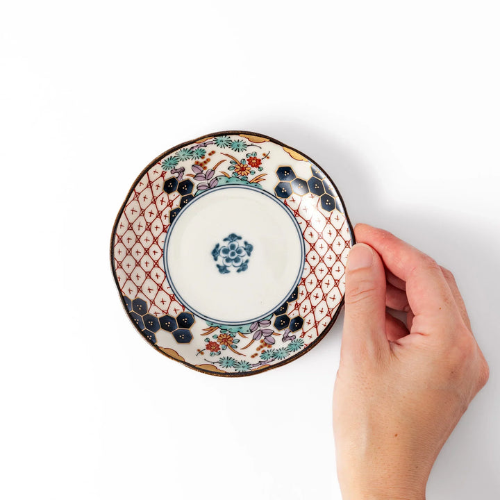 Scalloped Japanese sauce dish with red lattice floral motifs and navy hexagon accents for traditional dining.