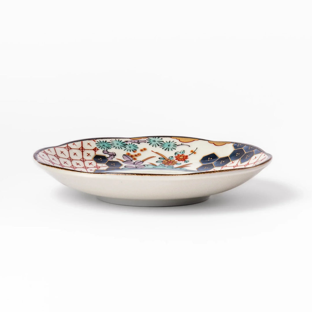 Scalloped Japanese sauce dish with red lattice floral motifs and navy hexagon accents for traditional dining.