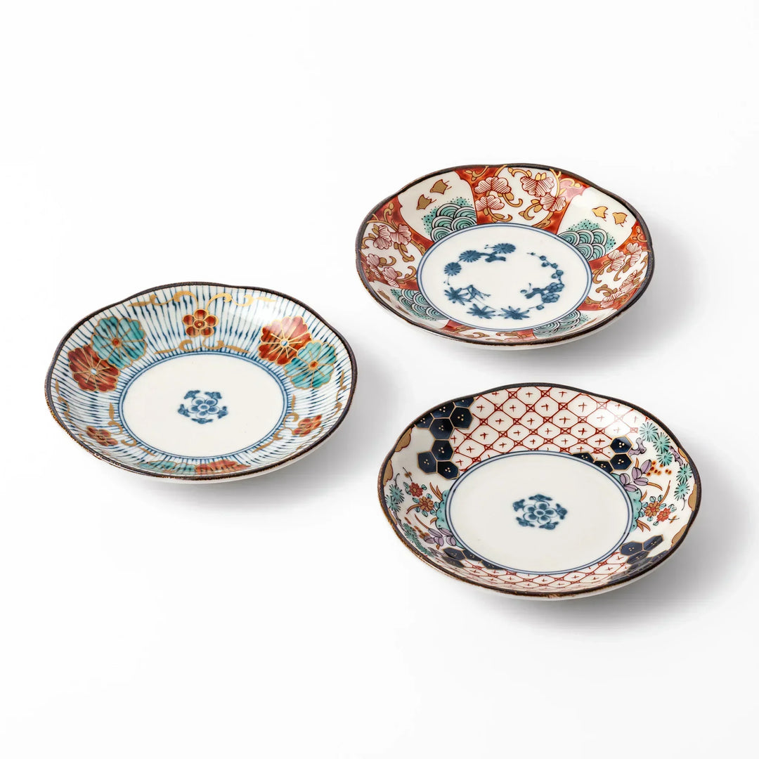 Set of three scalloped Japanese sauce dishes with red blue and gold floral patterns ideal for condiments.